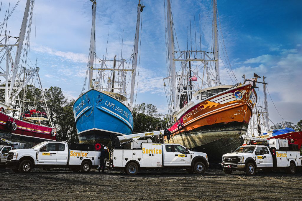 Boats and service trucks on land.