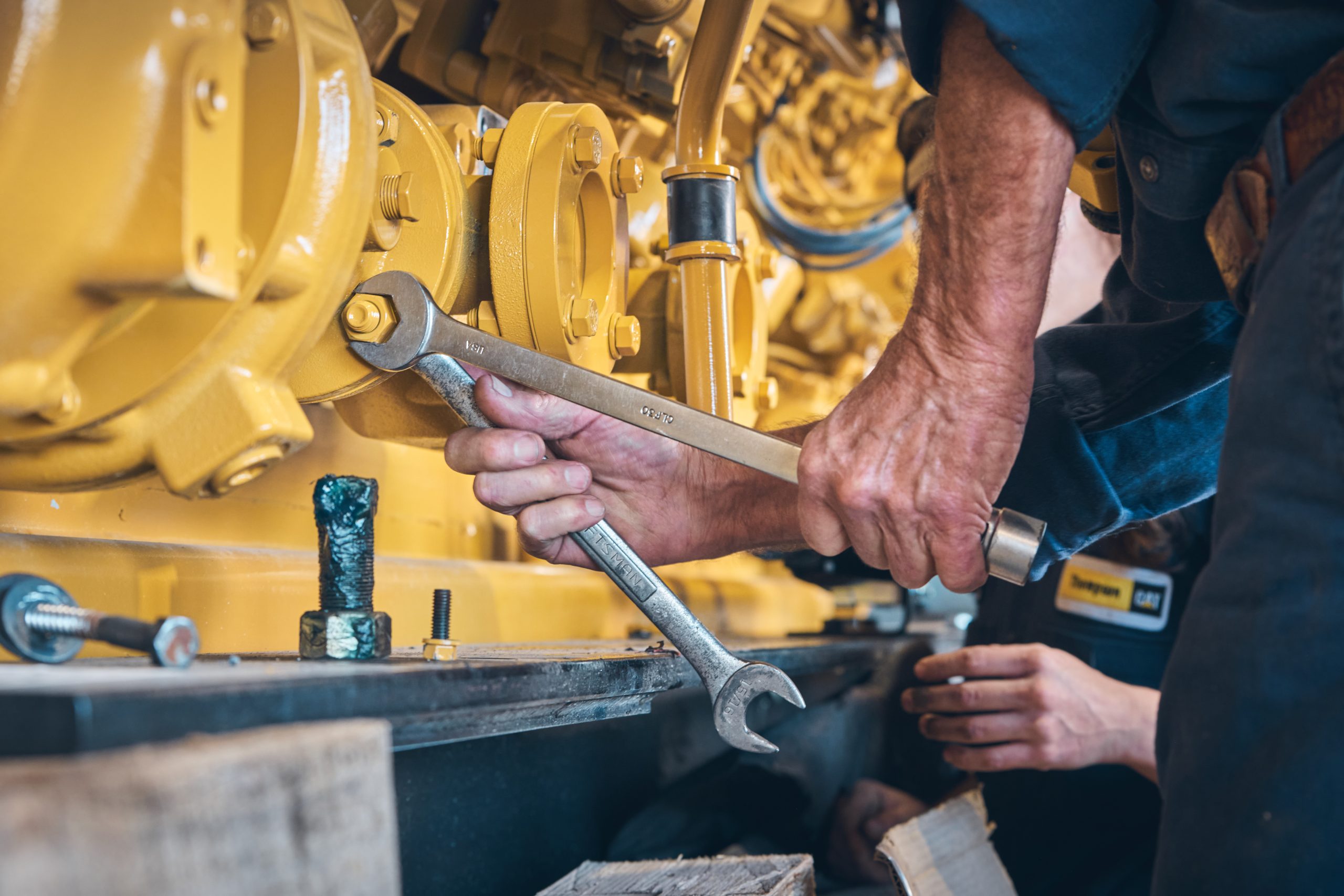 Hands using a wrench on machinery